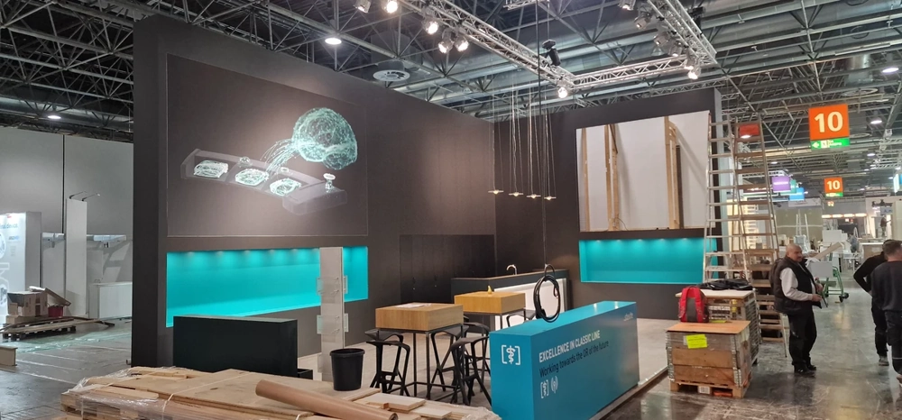 Messestandbau mit modularen Wandelementen, Theken und Beleuchtung in Messehalle