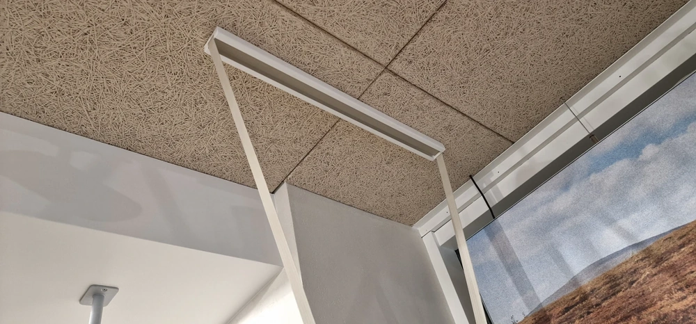 Installation einer weißen Rasterdecke mit quadratischen Akustikplatten und Leuchtenprofil – Rasterdecke