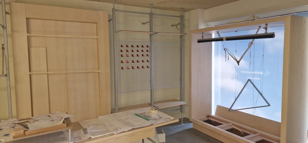 Montage von Holzpaneelen, Metallrahmen und Werkbank im Rohbau eines Messestands Messestandbau