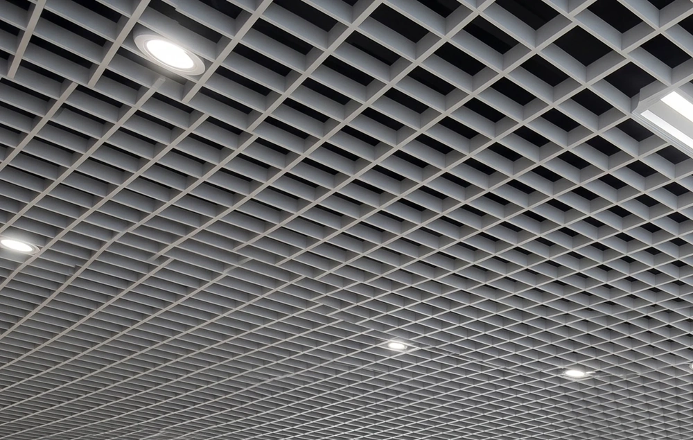 Weiße Rasterdecke mit quadratischem Gitterprofil und integrierten Deckenspots