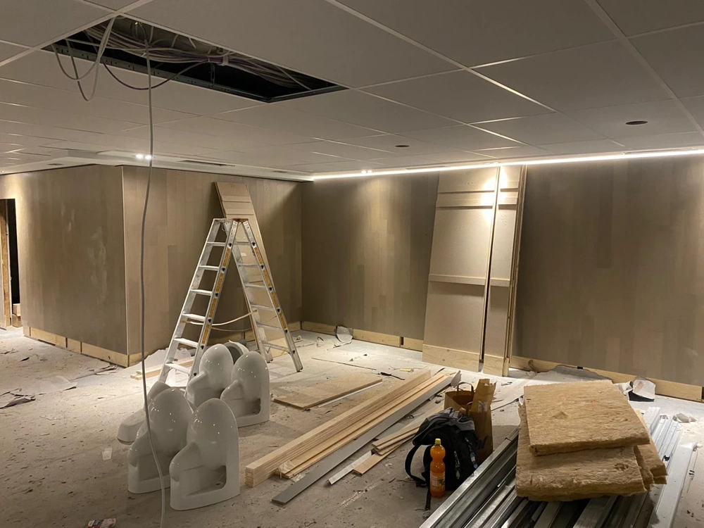 Montage Abgehängte decke in unfertigem Raum mit Leiter, Dämmplatten und Stahlprofilen