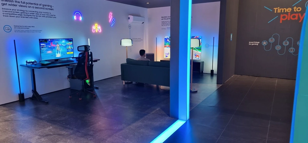 Messestandbau mit Gaming-Setup: Schreibtisch, Gaming-Stuhl, Bildschirme und LED-Beleuchtung