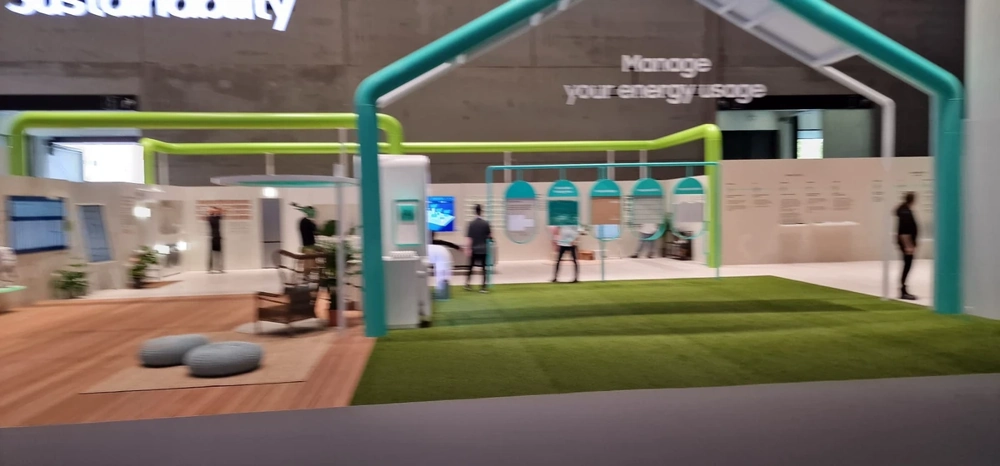 Messestandbau mit modularen Wänden, Holzpodest und Kunstrasen in einer Messehalle