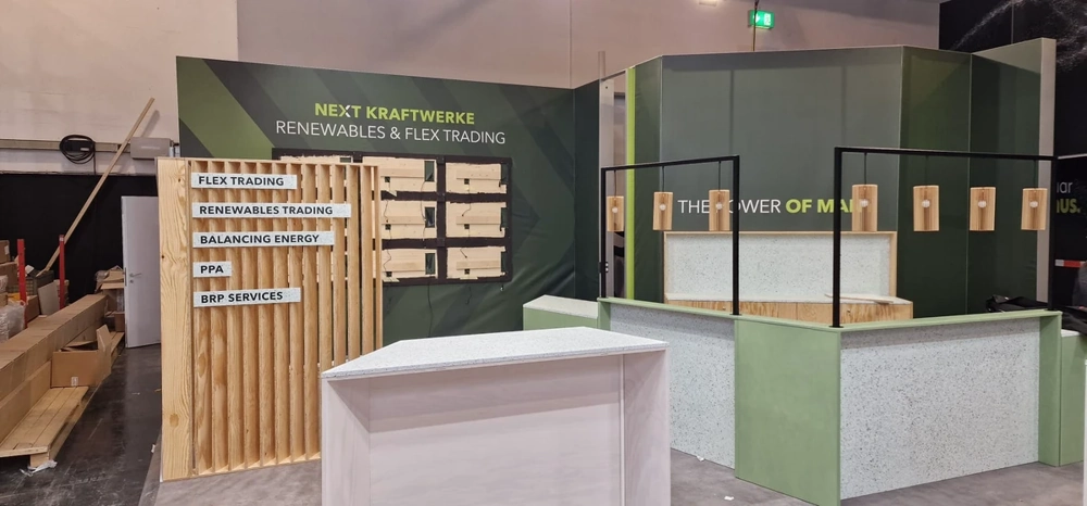 Bau eines Messestands mit Holzrahmen, Trennwänden und Thekenmodulen in Messehalle