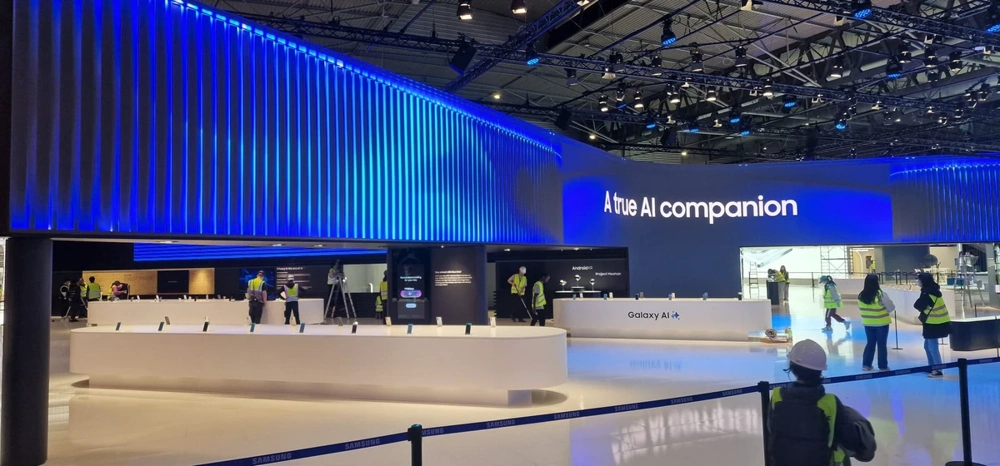 Montage eines weißen Messestands mit geschwungenen Theken und Besatzung in Warnwesten unter LED-Banner