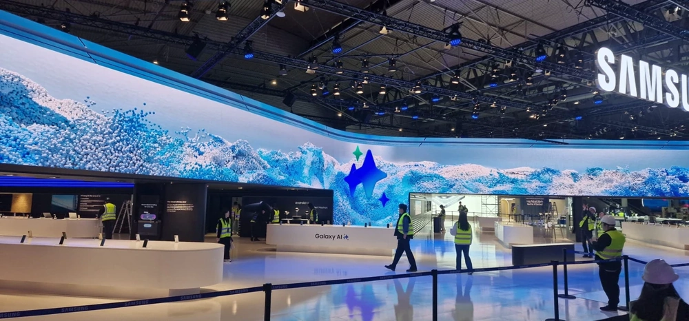 Arbeiter montieren einen Messestand mit gebogener LED-Videowand und Thekenbereich in Halle – Messestandbau