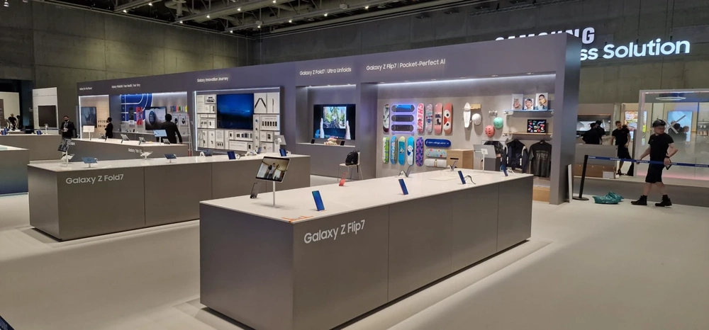 Moderne Messestand mit grauen Verkaufstresen und Präsentationsflächen für Produktdemonstrationen – Messestandbau
