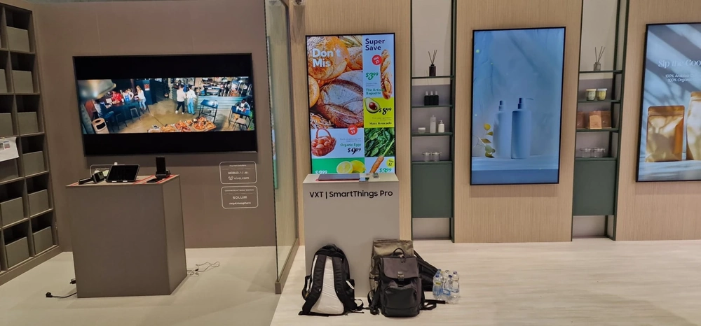 Messestand mit montierten Bildschirmen, Werbetafeln, Regalsystemen und Beleuchtung