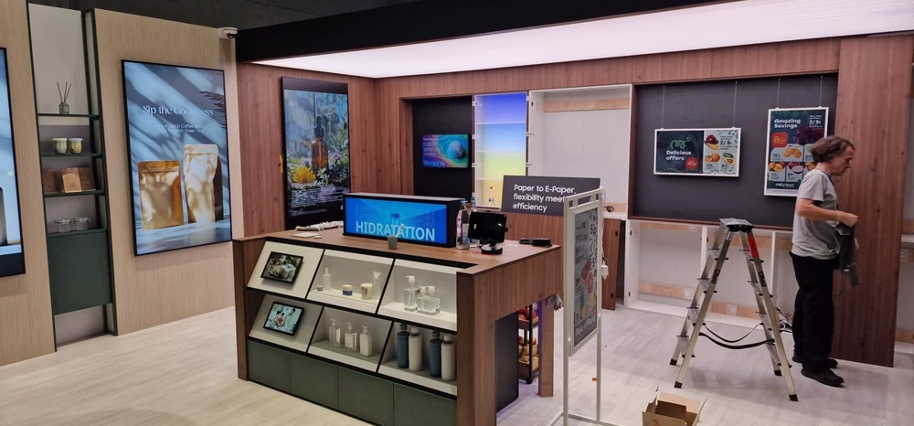 Messestandbau mit Holzpaneelen, Präsentationsregal, Screens, Leiter und Monteur