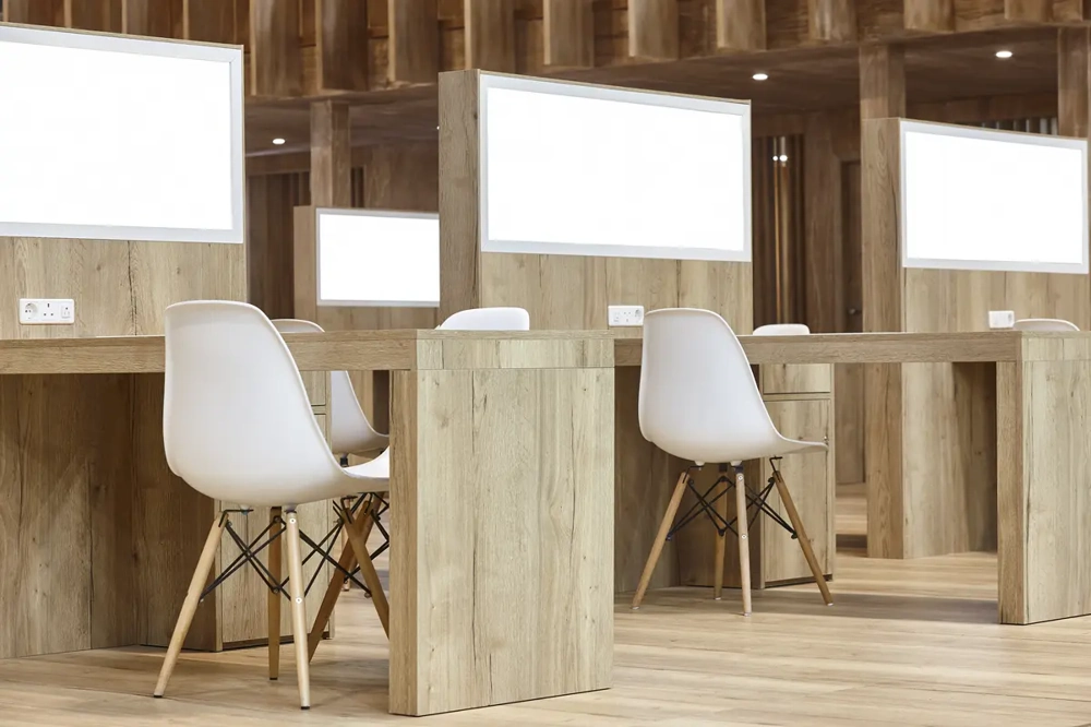 Moderne Holz-Arbeitsplätze mit weißen Trennwänden und Stühlen – Büromöbelmontage